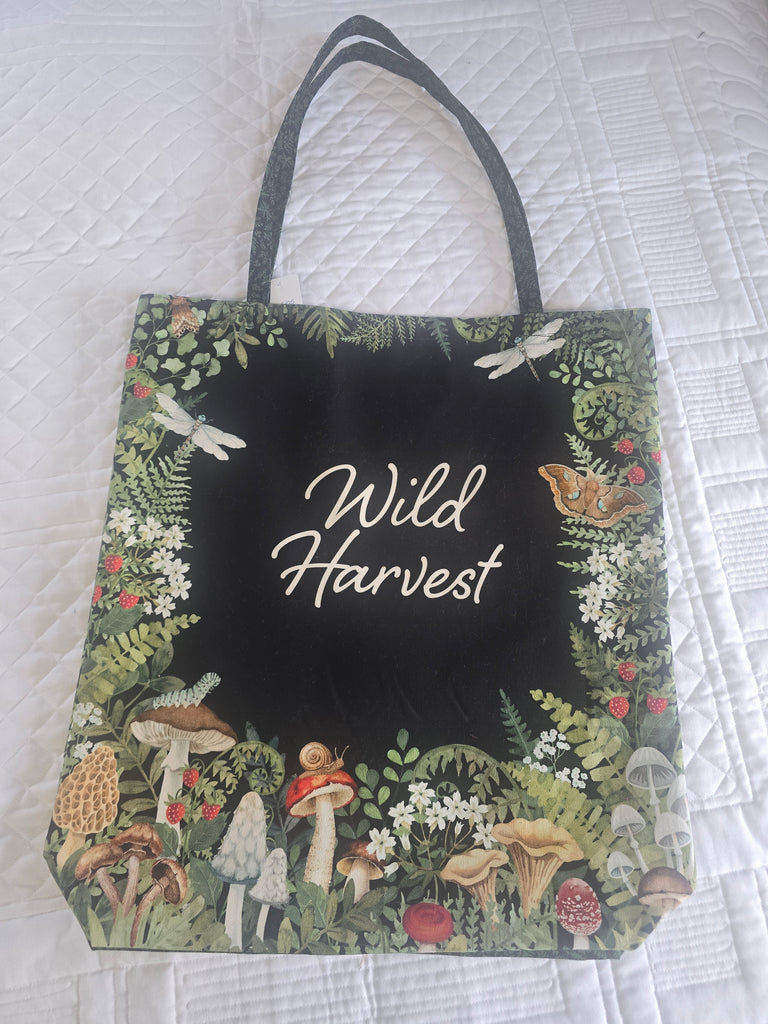 Floral and mushroom patterned bag with 'Wild Harvest' text on a white textured background